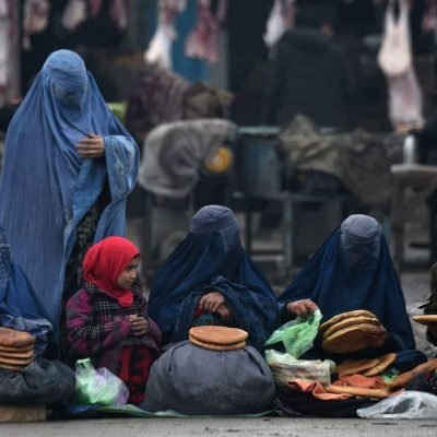 In this photograph taken on January 31, 2019, Afghan women wearing burqas sell bread on a street in Mazar-i-Sharif. (Photo by FARSHAD USYAN / AFP)        (Photo credit should read FARSHAD USYAN/AFP/Getty Images)